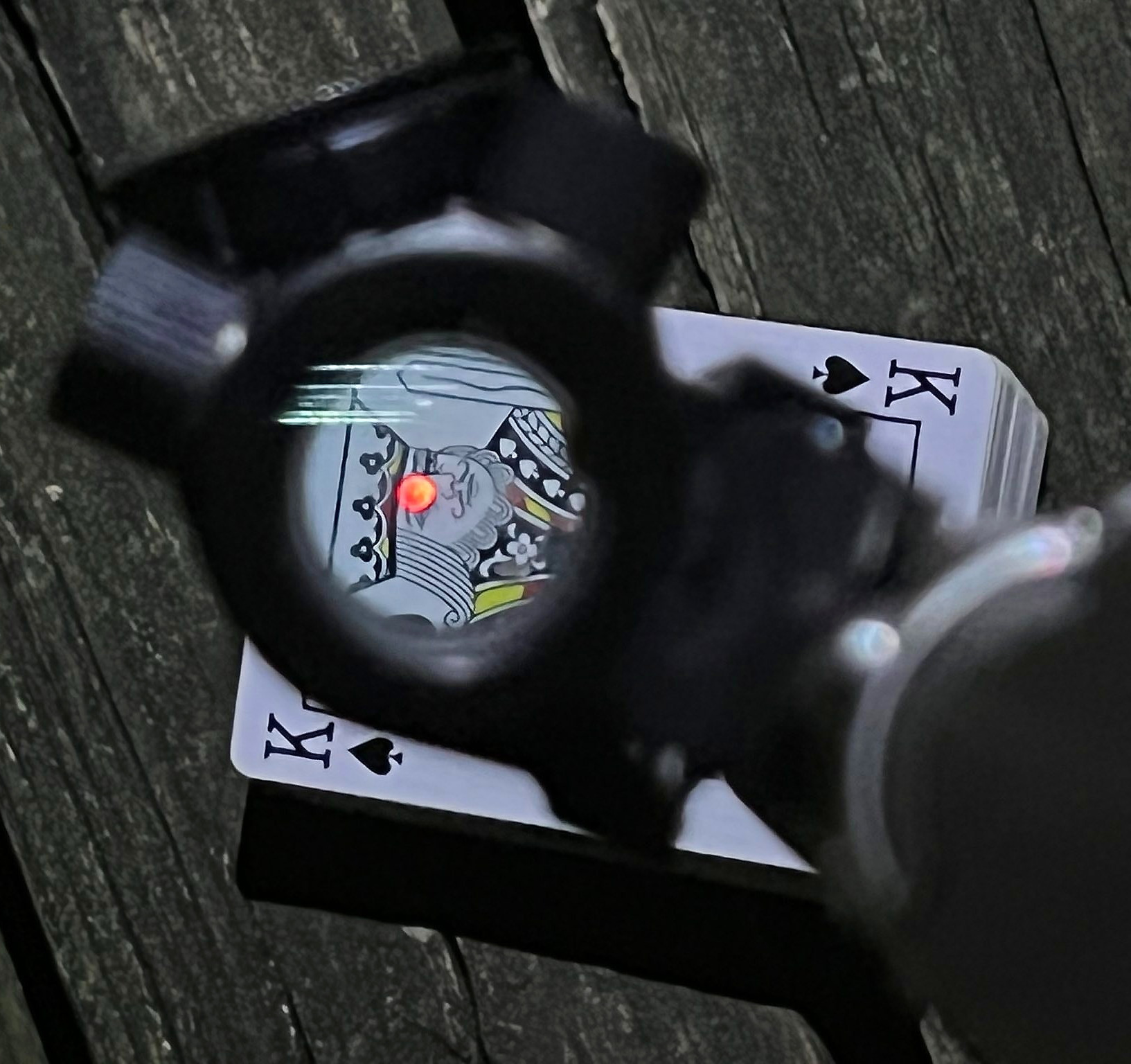 red dot pistol aiming at the king of spades